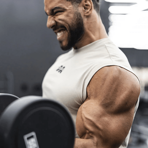 Deportista masculino en el gimnasio bebiendo Nitro-Tech® después de un entrenamiento intenso para la recuperación muscular.