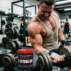 Atleta entrenando pesas con vascularidad y congestión muscular extrema